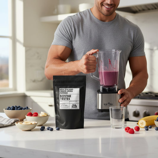Man holding a blender with a purple smoothie, surrounded by ingredients and a package on a kitchen counter.
